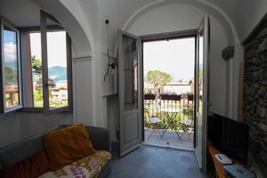 梅纳焦Due Colonne的带沙发的客厅和通往阳台的门