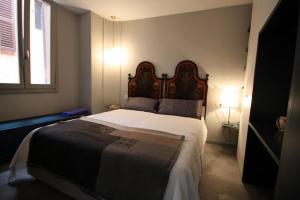 梅纳焦Due Colonne的一间卧室配有一张大床和木制床头板