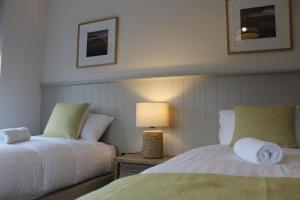 本拉提Bunratty west Townhouse的一间卧室设有两张床和一张桌子上的台灯。