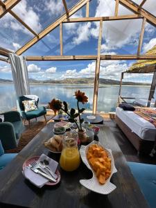 普诺Hotel - Titicaca Dora的一张桌子,上面有食物,享有水景