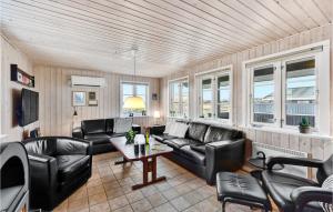 比耶勒高Amazing Home In Hvide Sande With 3 Bedrooms, Sauna And Wifi的客厅配有黑色皮革家具和窗户。