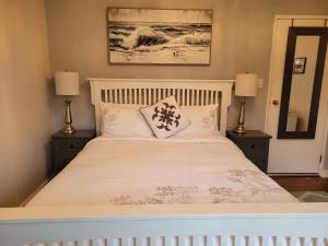 纳奈莫Campbell Cottage B&B的卧室配有带两盏灯的白色床