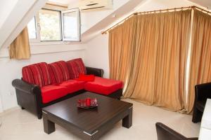 扎金索斯镇Attic flat ''Tsoukalas Group''的客厅配有红色的沙发和桌子