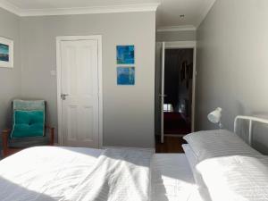 班戈北爱尔兰Loughview的卧室配有白色的床和蓝色椅子