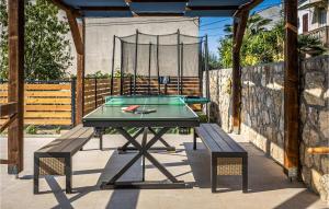 奥米沙利Awesome Home In Omisalj With Kitchen的天井上的乒乓球桌和2张长凳