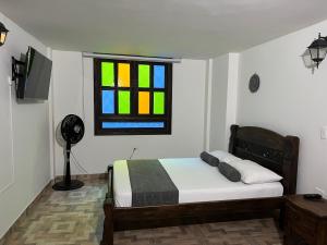 卡利Santiago DC Hotel的一间卧室设有一张床和一个彩色玻璃窗