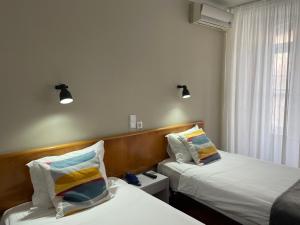 英雄港Hotel Ilha的酒店客房设有两张床和窗户。