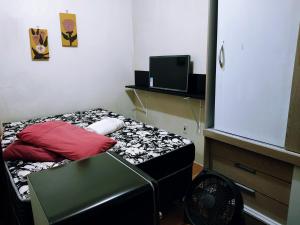 里奥格兰德Casa Excelente Localização!的小房间设有一张床和一个风扇