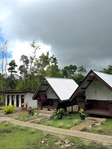 BatuanROCA'S HOMESTAY Backpackers Chalet Bohol的两顶房子和院子