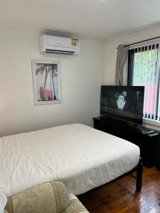 DoonsideFragrant Homes-68B independent aircon room, with 65’TV, queen size beds, rest sofa, built in wardrobe的一间卧室配有一张床和一台平面电视