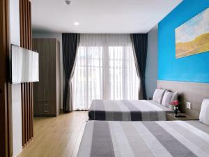 芽庄HÀO PHÁT HOTEL NHA TRANG的酒店客房设有两张床和窗户。