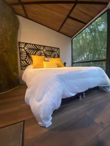 金巴亚Amanatu Ecolodge & Spa的一间卧室配有一张带黄色枕头的大床