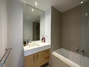 墨尔本Prima Tower Apartment Face to Crown by GoodLive的一间带水槽、浴缸和镜子的浴室
