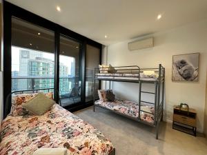 墨尔本Prima Tower Apartment Face to Crown by GoodLive的一间带两张双层床的卧室和一个阳台