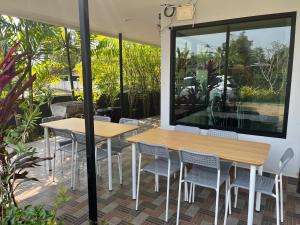 蔻立Chill Home Pool Villa Khao Lak的一个带2张桌子和椅子的庭院和大窗户。