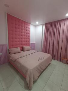 居銮米米民宿的一张大床,在房间内配有粉红色床头板