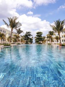 富国Nakichi Hotel Phú Quốc的一座棕榈树和建筑的大型游泳池