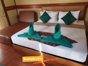 考索The Royal Bamboo Lodges - SHA Certified的一张带两张绿色毛巾的床