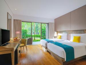 金巴兰莫瓦匹克金巴兰巴厘岛度假Spa酒店的酒店客房配有一张床、一张书桌和一台电视。