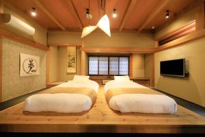 富士河口湖富士温泉寺梦殿日式旅馆的配有电视的客房内的两张床