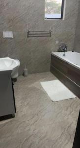 卢萨卡Pisano Luxury Apartments的一间带水槽、浴缸和卫生间的浴室