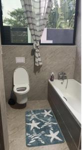 卢萨卡Pisano Luxury Apartments的带浴缸、卫生间和浴缸的浴室。