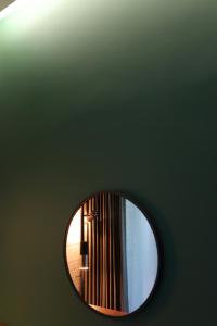 首尔LE SEOUL HOTEL的绿墙上的圆镜子和灯
