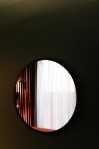 首尔LE SEOUL HOTEL的一面墙上的圆镜子,一面有窗户