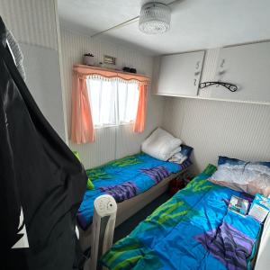 德哈恩Caravan 2 bedroom - New Camping Ideal的小房间设有两张床和窗户