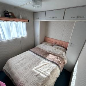 德哈恩Caravan 2 bedroom - New Camping Ideal的一间小卧室,角落里设有一张床