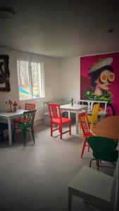尼布鲁Orrefors Vandrarhem的一间设有五颜六色的桌椅和绘画的房间