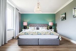 朗格奥Ferienwohnung Hus up Höcht的一间卧室配有一张带蓝色墙壁的大床