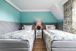 朗格奥Lieblingsinsel Langeoog的蓝色墙壁客房中的两张单人床