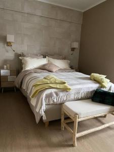列日Studio Montaigne的卧室配有白色大床和长凳