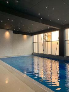 库克斯巴扎白兰花酒店的大楼内的一个蓝色海水游泳池