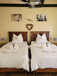 GrootfonteinFiume Lodge CC的客房内的两张床和白色床单