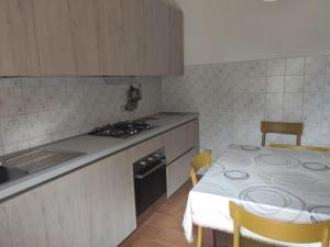 波蒙特Appartamento Il Girasole的厨房配有桌子、炉灶和桌椅