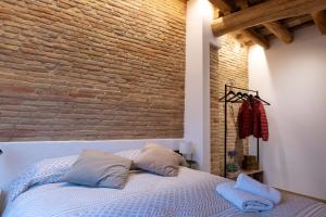 维克Niu del Sol的一间卧室设有砖墙和一张带枕头的床