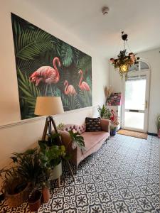 托基Flamingo Lodge的客厅配有粉红色的沙发和火烈鸟绘画