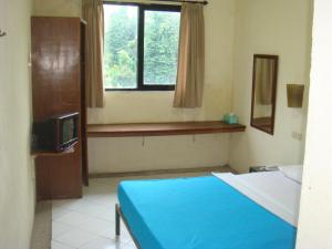 SukanegaraSunset View Carita by Augusta hotel的一间卧室设有蓝色的床和窗户。