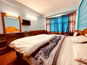 马拉里Hotel D Kanchan Manali的一间卧室配有两张单人床和一台电视机
