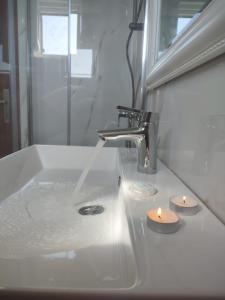 扎瓦拉提卡Apartments Laus的浴室水槽配有水龙头和2把蜡烛