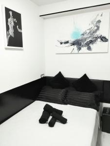 巴塞罗那Vilapicina Hostal的卧室配有带黑色枕头的白色床