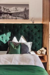 蒂罗尔-泽费尔德凯撒霍夫维塔酒店的一张带枕头的绿色床头板