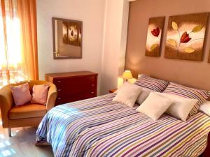 科尔多瓦Apartamento Zoco Córdoba的一间卧室配有一张大床和一把椅子