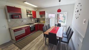 马里博尔Apartma4us的厨房配有红色橱柜和桌椅