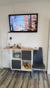 马里博尔Apartma4us的一张桌子,墙上有一台电视,椅子