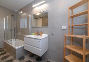 提比里亚Yalarent Europe apartments- Luxury big apartmens with lake view的一间带水槽、淋浴和镜子的浴室