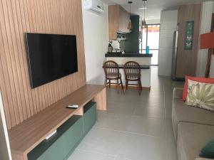 伊塔齐米林Itacimirim Beira Mar的客厅设有壁挂式平面电视。