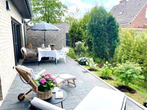 WeenerFreya Blue Ferienhaus的庭院配有桌椅和遮阳伞。